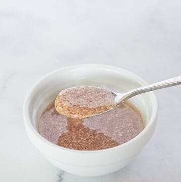Flax egg in a white bowl being scooped with a spoon.