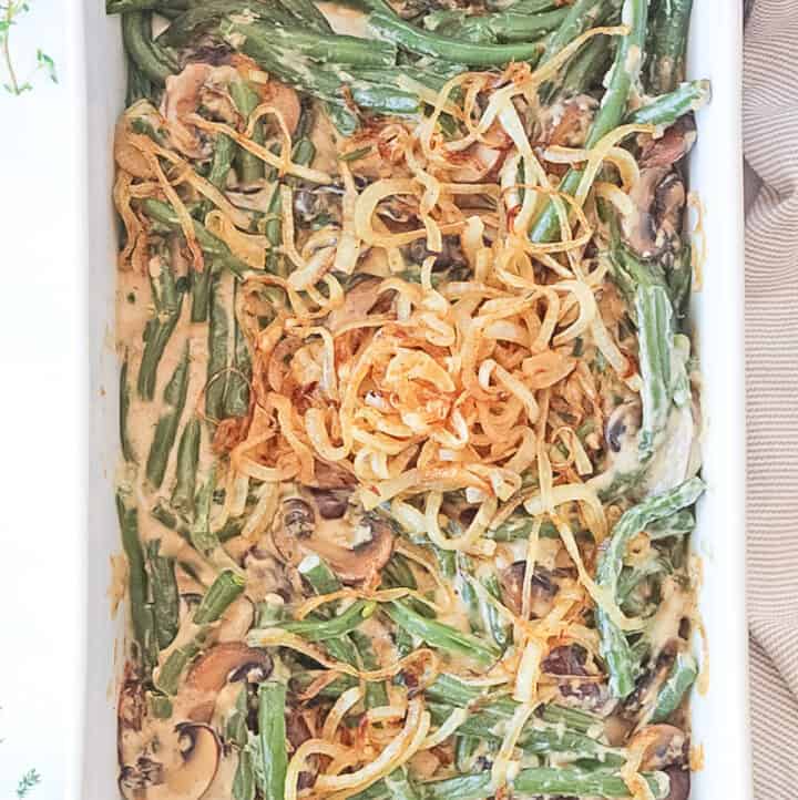 Overhead view of a white baking dish filed with a homemade green bean casserole topped with caramelized onions.