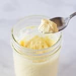 Homemade Mayo being scooped out of a mason jar with a spoon.