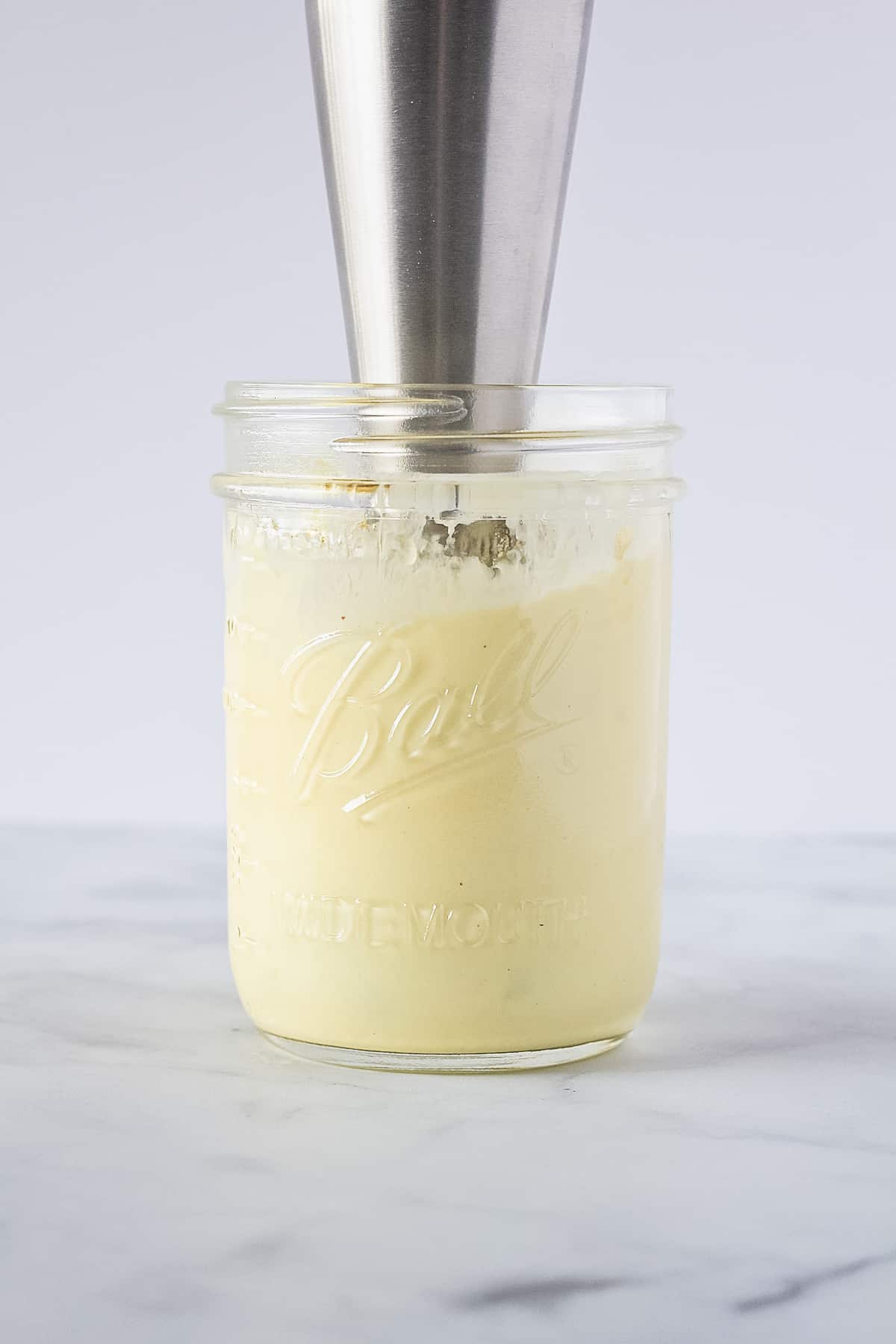 Immersion blender in a pint mason jar with homemade mayo.