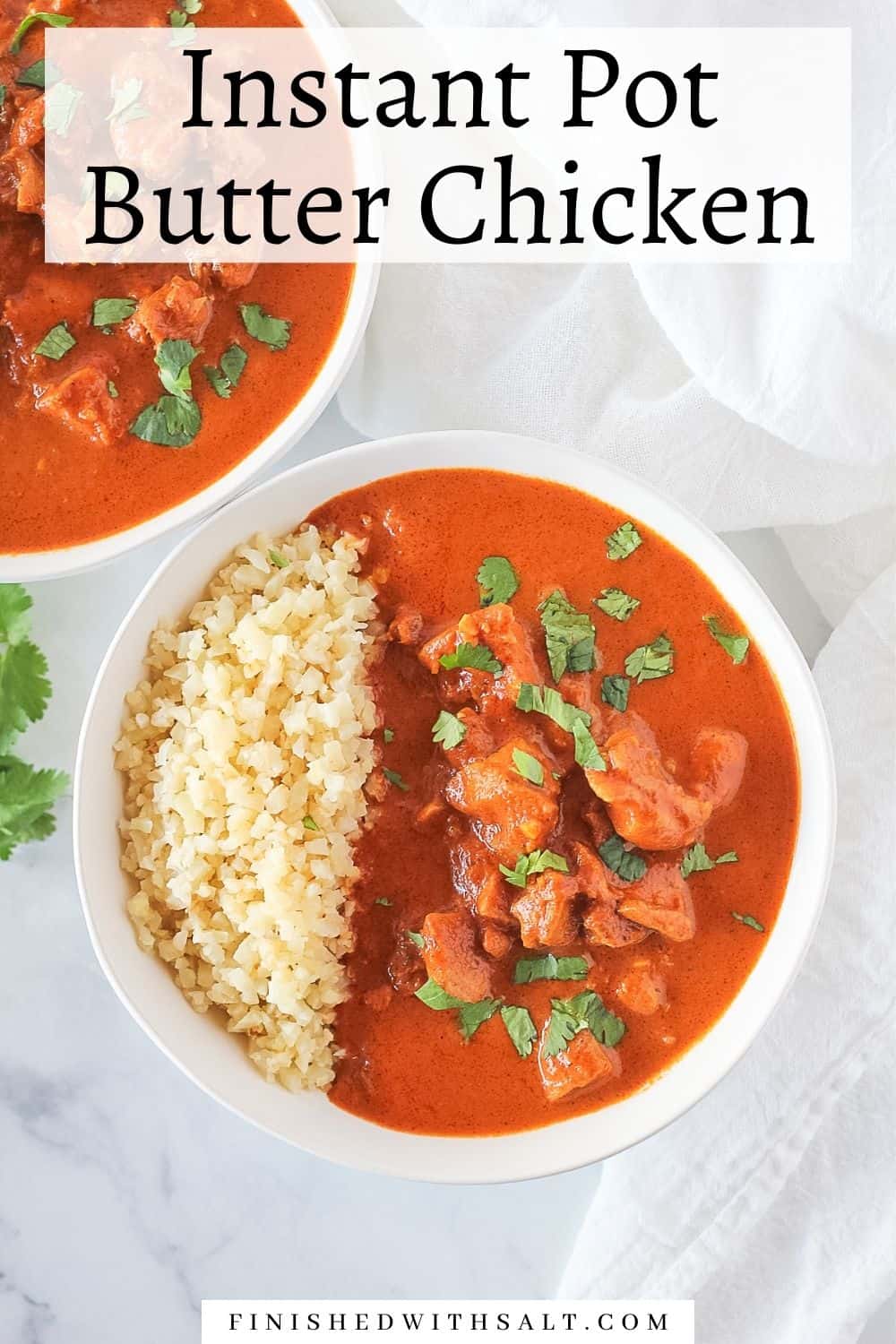 Two white bowls full of Butter Chicken with rice and sprinkled with cilantro.