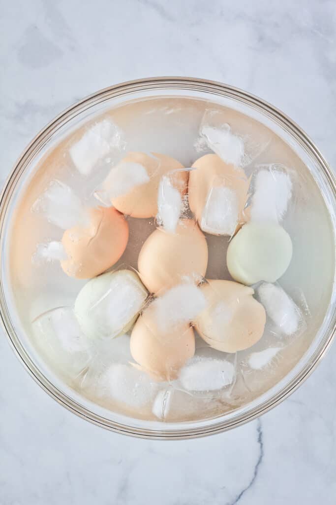 Instant Pot Hard Boiled Eggs in an ice bath in a clear glass bowl.