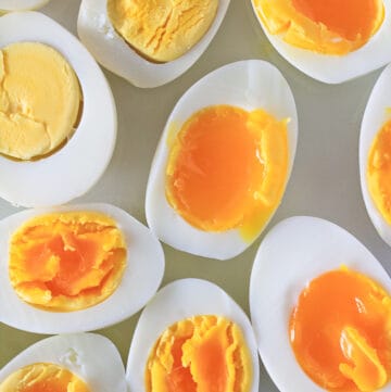 Close up of a white plate with three different styles of instant pot hard boiled eggs.