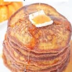 Maple Syrup being poured over a stack of pumpkin pancakes with butter including recipe title.