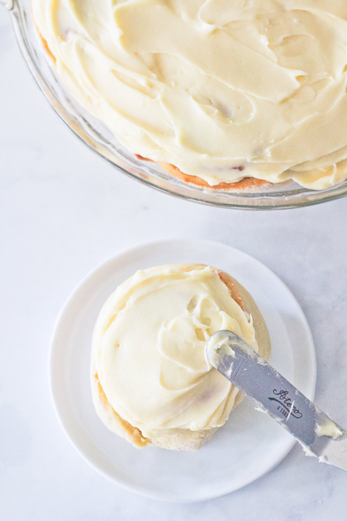 Cinnamon roll being frosted.