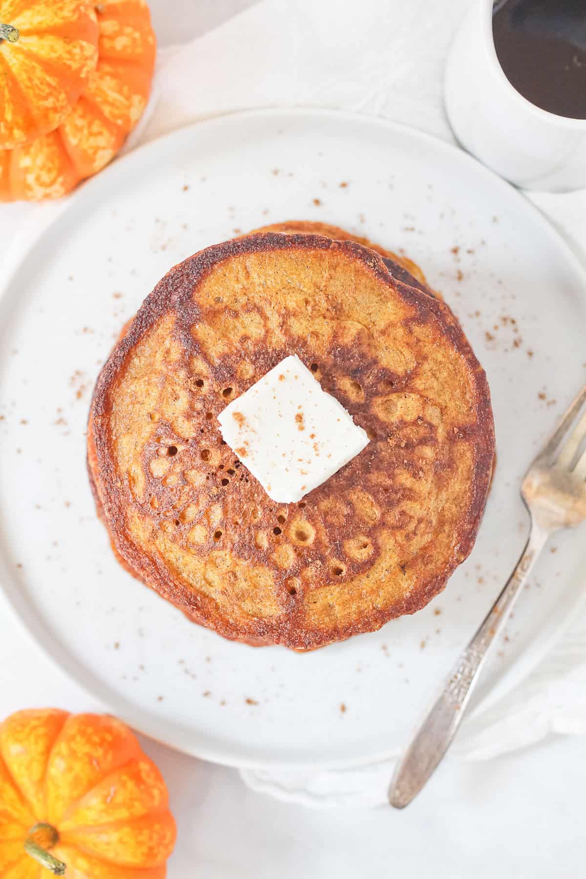 Einkorn Pumpkin Pancakes on white plate with fork.